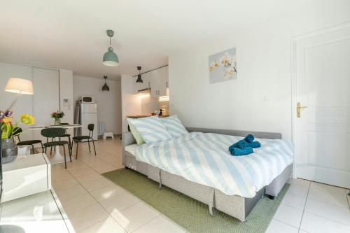 a bedroom with a bed with a blue teddy bear on it at T2 Confort Lyonnais Métro République Garage fermé in Villeurbanne