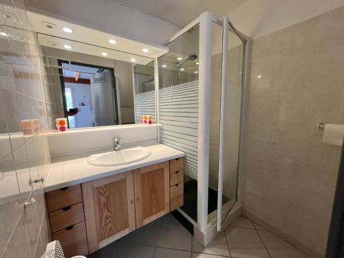 une salle de bain avec un lavabo et une douche dans l'établissement Belle villa d'angle, 6 couchages, cuisine climatisée, 3 chambres terrasse ombragée parking dans résidence sécurisée avec piscine commune, 400 m de la mer, LROND24, à Portiragnes