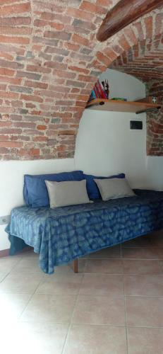 a couch in a room with a brick wall at Albaluna 2 casa vacanza in Dronero
