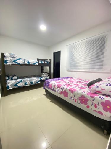 a bedroom with a bed and two bunk beds at Cómodo & Económico Apartamento para 4 pax en La Boquilla in Cartagena de Indias