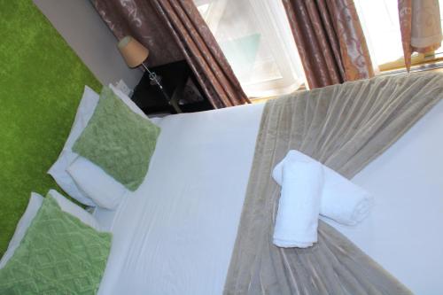 a bed with a roll of toilet paper on it at Cockpit Guest House Kempton Park Airport Getaway in Kempton Park