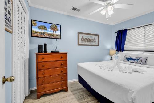 a bedroom with a white bed and a dresser at Sea Cabin in Myrtle Beach