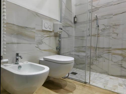a bathroom with a toilet and a sink and a shower at Hotel Ancora in Verbania