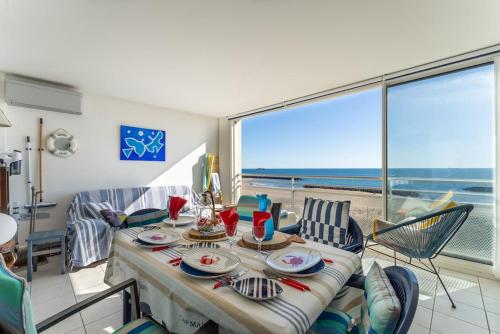 une salle à manger avec une table et une vue sur l'océan dans l'établissement MOM' Blue Paradise Front de Mer 61 m2 CArPe Diem 3 étoilés - 3 Clim, Wifi, lit 160 - 4è Ascenseur Parking, Piscine, Pétanque, Ping-pong - Pistes cyclables, GOLF à 5 mn, au Cap d'Agde