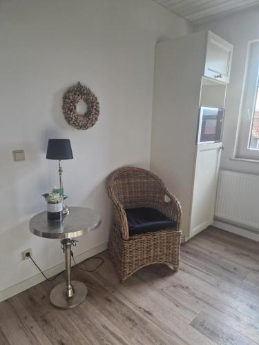 a room with a wicker chair and a table at Hildebrandts Landhotel in Klettbach