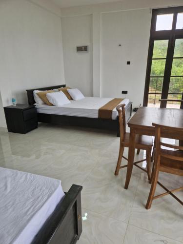a bedroom with a bed and a table and chairs at Aruni Villa - Knuckles Range 