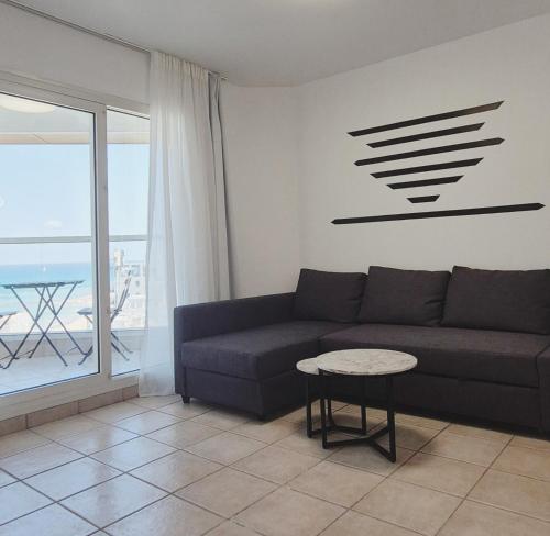 a living room with a couch and a table at GO to apartments in Leonardo in Bat Yam