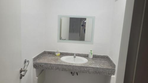 a bathroom with a sink and a mirror at Appartement Élégant avec vue plage et montagne d'arganier Family Only in Imi Ouaddar