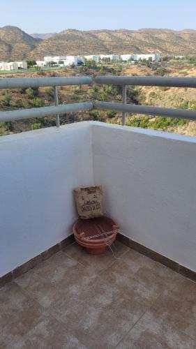 a bag sitting on top of a balcony at Appartement Élégant avec vue plage et montagne d'arganier Family Only in Imi Ouaddar