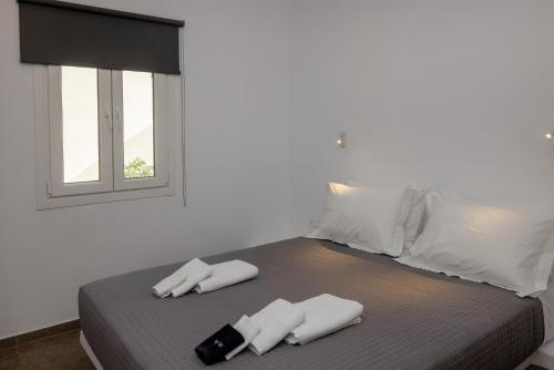 a bed with two white towels and a window at Green Dream in Tinos Town
