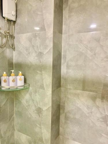 a bathroom with a shower with three candles on a shelf at Primeworld District Condoresort 15mins2airport in Mactan Island