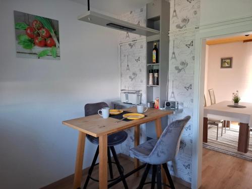 a small kitchen with a wooden table and two chairs at Ferienwohnung am Bach in Altenkunstadt