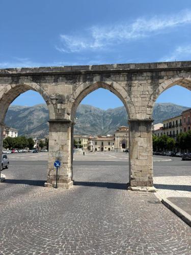 a stone archway in the middle of a street at Piazza Maggiore in Sulmona