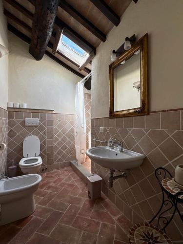 a bathroom with a sink and a toilet and a mirror at Borgo Chiantina in Cortona