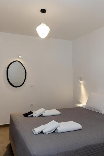 a bedroom with a large bed with a mirror on the wall at Green Dream in Tinos Town
