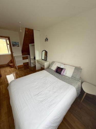 a large white bed in a bedroom with a chair at Private Room in Skellig Apartment in Portmagee