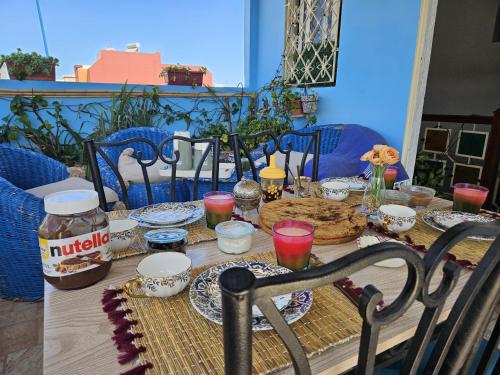 a table with plates of food and drinks on it at Appartement avec Terrasse in Larache