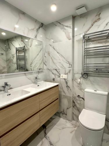 a bathroom with a sink and a toilet and a mirror at Playa Sol 2 in Denia