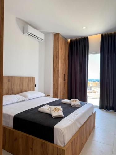 a bedroom with a large bed with two pillows on it at Kompleksi Muja in Velipojë