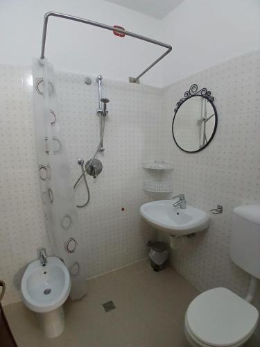 a bathroom with a shower and a toilet and a sink at Albergo Ristorante Gualtieri in Barberino di Mugello