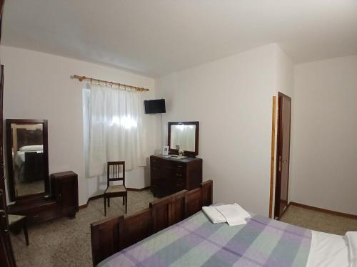 a bedroom with a bed and a dresser and a mirror at Albergo Ristorante Gualtieri in Barberino di Mugello