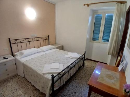 a bedroom with a bed and a table and a window at Albergo Ristorante Gualtieri in Barberino di Mugello