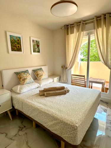 a bedroom with two beds and a large window at Playa Sol 2 in Denia