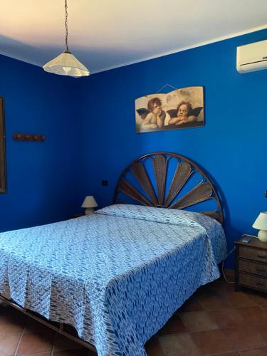 a blue bedroom with a bed with a blue wall at Villa Laura in Coccorino