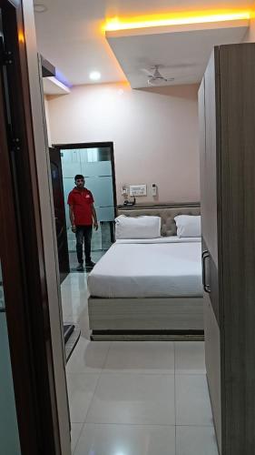 a man standing in a bedroom with a bed at Hotel JD Inn 