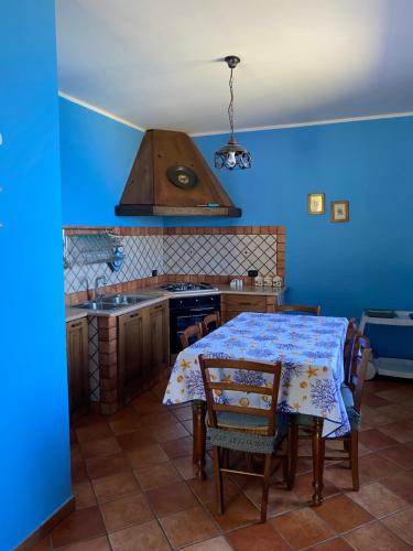 a kitchen with a table and a blue wall at Villa Laura in Coccorino