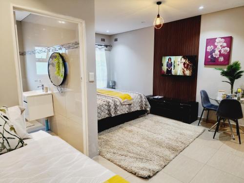 a bedroom with two beds and a bathroom with a mirror at Eastern Road Executive Suites in Harare