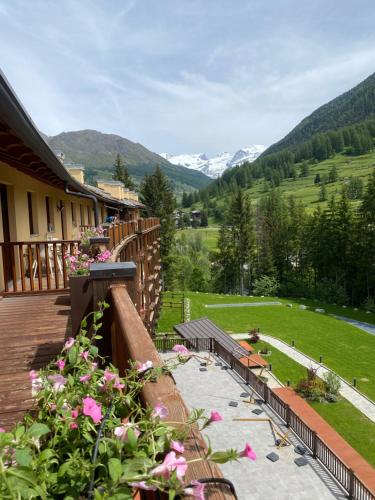 a balcony with a view of a field and mountains at Maison Poluc Boutique Hotel in Champoluc