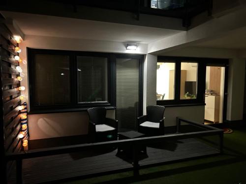 a room with two chairs and a desk with windows at Premium Holidays Apartamenty przy plaży in Rowy