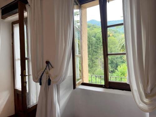 a room with a window with a view of a mountain at Antico Borgo Sanda Lago Maggiore in Casalzuigno