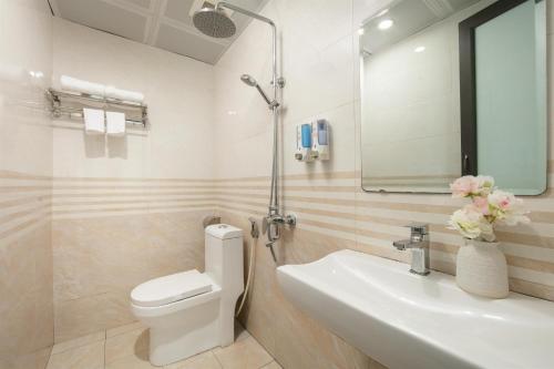 a bathroom with a sink and a toilet and a mirror at Tung Bach Boutique Hotel in Lãm Dương