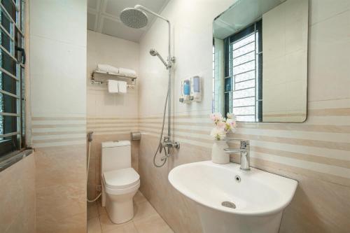 a bathroom with a sink and a toilet and a mirror at Tung Bach Boutique Hotel in Lãm Dương