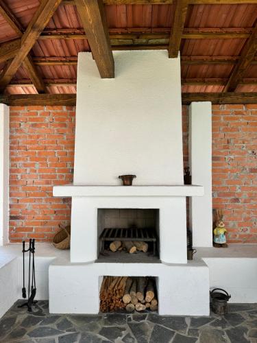 a white fireplace in a room with a brick wall at Forest House Retreat in Curtea de Argeş