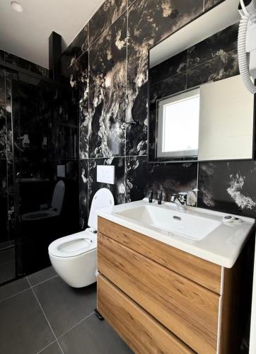 a bathroom with a white sink and a toilet at Kompleksi Muja in Velipojë