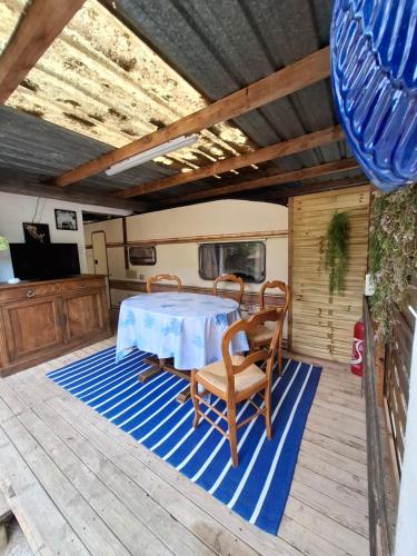 einen Tisch und Stühle auf einer Terrasse mit einem Tisch in der Unterkunft Côté plage in Vias