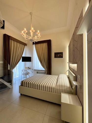 a bedroom with a bed and a chandelier at Le Suite del Duomo in Cava deʼ Tirreni