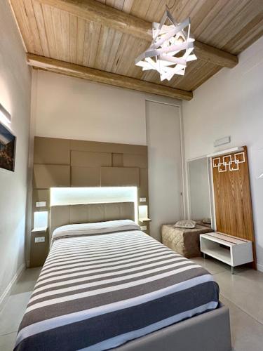 a bedroom with a large bed and a chandelier at Le Suite del Duomo in Cava deʼ Tirreni