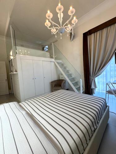 a bedroom with a bed with a staircase and a chandelier at Le Suite del Duomo in Cava deʼ Tirreni