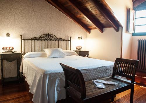 a bedroom with a large bed with a wooden headboard at Casa de Costoia in Santiago de Compostela