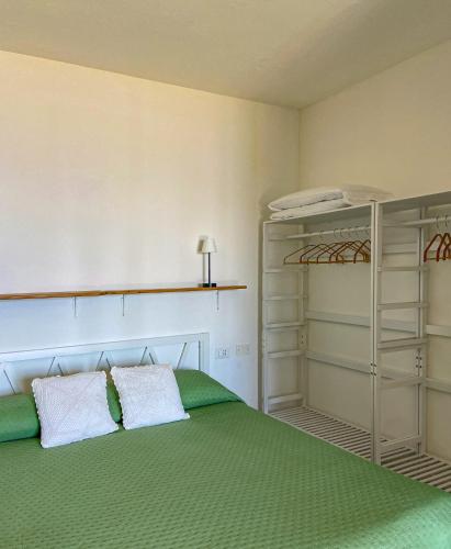 a bedroom with a green bed and a shelf at Residence Intur in Marciana Marina