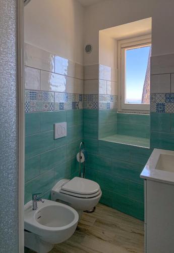 a green bathroom with a toilet and a sink at Residence Intur in Marciana Marina