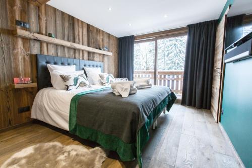 - une chambre avec un lit et un mur en bois dans l'établissement Chalet Le Saint-Jean - 15 pers - proche pistes, aux Gets
