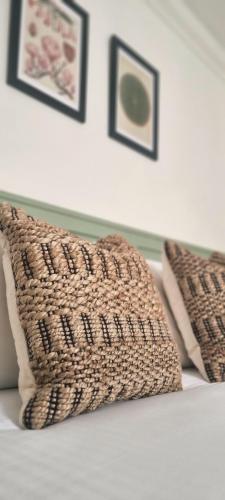 two pillows on a bed with pictures on the wall at Saint Margaret's Guest House in Poole