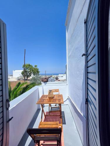 a patio with benches and a table on a balcony at Calypso Heaven in Santorini