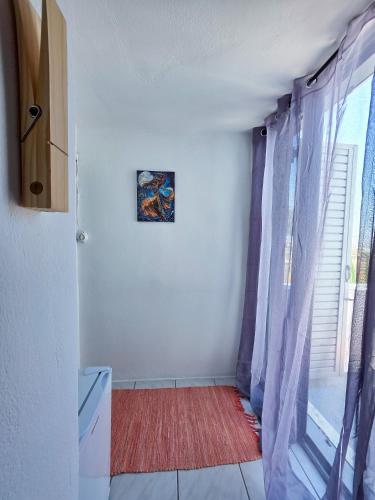 a room with a window and a red rug at Calypso Heaven in Santorini