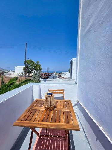 a wooden table and chair sitting on a balcony at Calypso Heaven in Santorini
